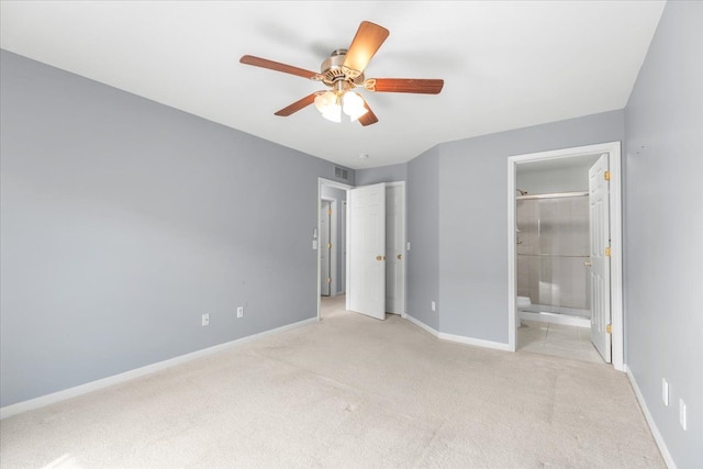 unfurnished bedroom with baseboards, ensuite bathroom, and carpet flooring