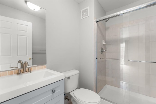 bathroom featuring visible vents, vanity, toilet, and a shower stall