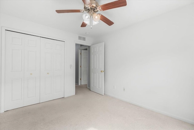 unfurnished bedroom featuring ceiling fan, visible vents, baseboards, a closet, and carpet