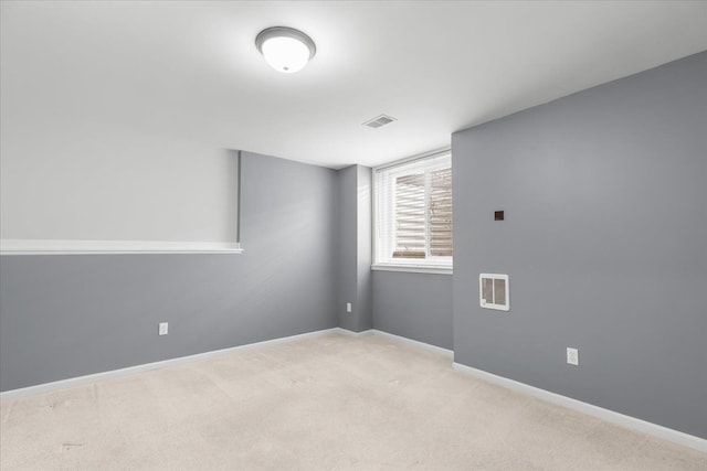 carpeted empty room featuring baseboards and visible vents