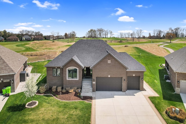 view of front of house with a front lawn, roof with shingles, brick siding, concrete driveway, and an attached garage