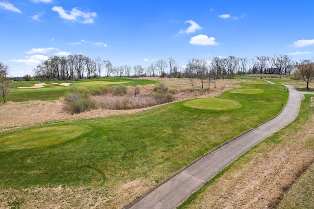 surrounding community with view of golf course and a yard