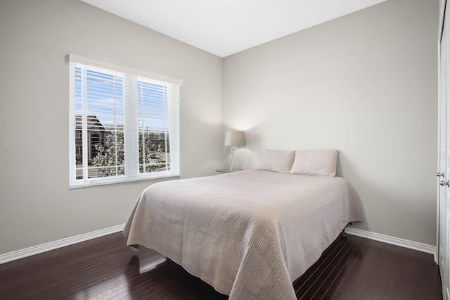 bedroom featuring baseboards and hardwood / wood-style flooring