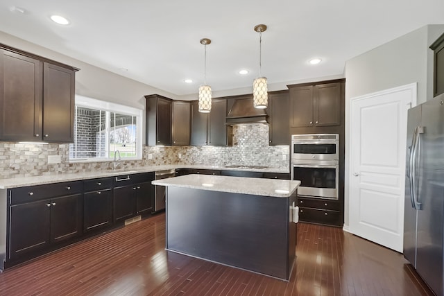 kitchen with dark wood-style flooring, stainless steel appliances, a sink, and dark brown cabinets