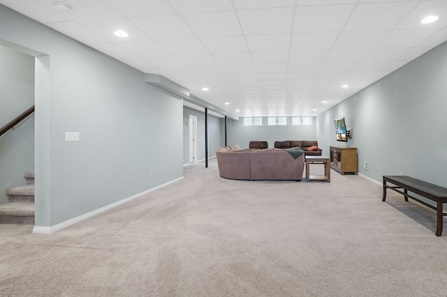 living area featuring carpet floors, baseboards, and stairs