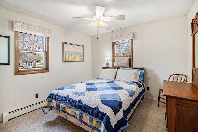 carpeted bedroom with a ceiling fan, a textured ceiling, and a baseboard heating unit