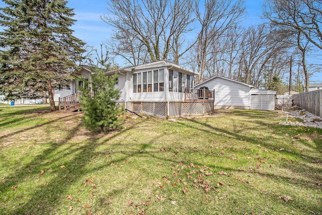 back of house featuring a sunroom, a lawn, fence, and a deck