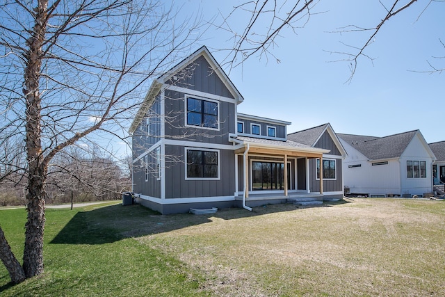 rear view of property with a lawn, board and batten siding, and roof with shingles