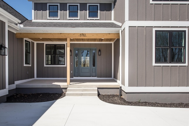 doorway to property with covered porch and roof with shingles