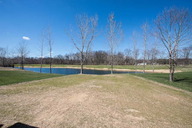 view of property's community with a lawn and a water view