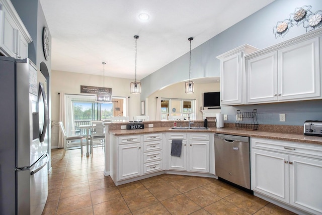 kitchen featuring a peninsula, a sink, appliances with stainless steel finishes, and white cabinets