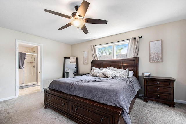 bedroom featuring baseboards, a ceiling fan, ensuite bathroom, and light carpet