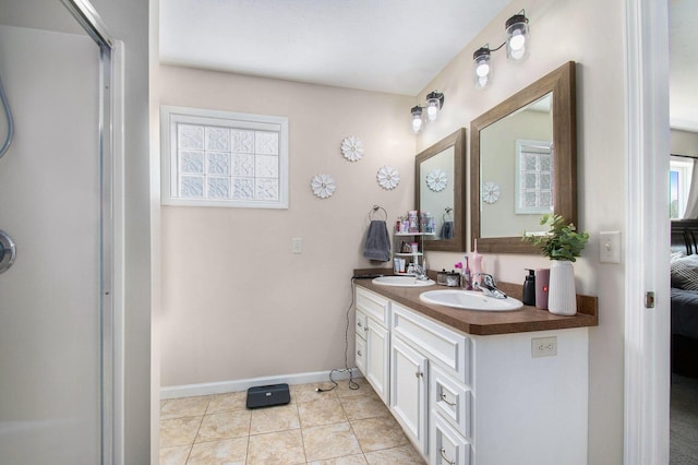bathroom featuring a sink, baseboards, plenty of natural light, and an enclosed shower