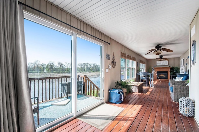 sunroom featuring a water view