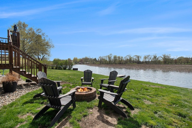 view of yard featuring a water view, stairs, and an outdoor fire pit