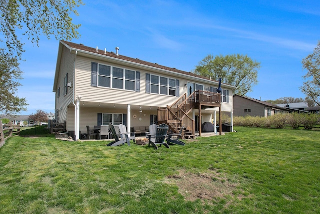 rear view of property featuring a deck, fence, an outdoor fire pit, a yard, and stairs