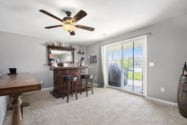 bar with carpet flooring, ceiling fan, a dry bar, and baseboards