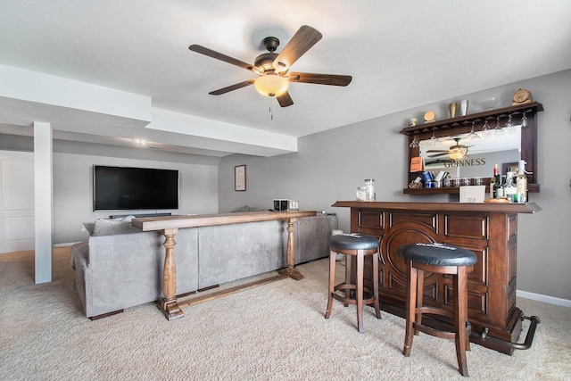 bar featuring carpet floors, a dry bar, baseboards, and ceiling fan