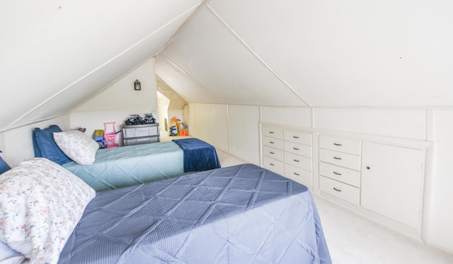 bedroom featuring light colored carpet and vaulted ceiling