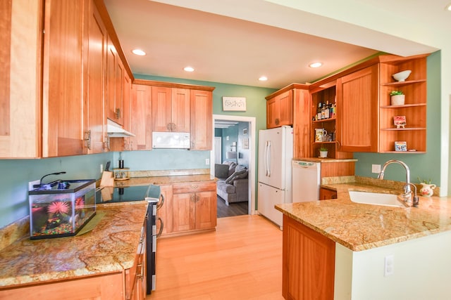 kitchen featuring open shelves, a sink, light wood finished floors, under cabinet range hood, and white appliances