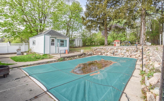 view of sport court with a storage shed, fence, and a fenced in pool