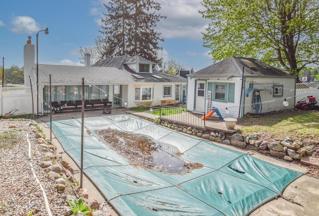 back of property with fence, a fenced in pool, and a patio