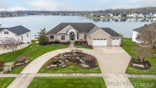 view of front of house with a water view, an attached garage, driveway, and a front lawn