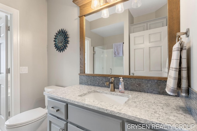 full bath with vanity, toilet, and a shower stall
