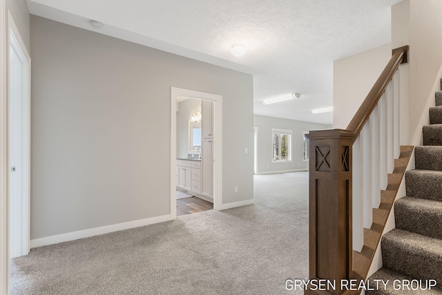 stairway with baseboards and carpet