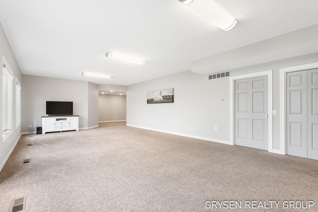 unfurnished living room with visible vents, carpet flooring, and baseboards