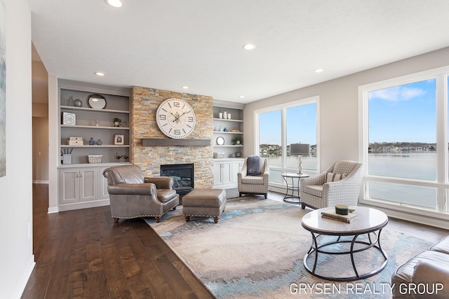 living area featuring a fireplace, built in shelves, recessed lighting, baseboards, and dark wood-style floors