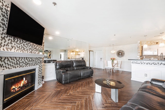 living room featuring recessed lighting, a wainscoted wall, and a fireplace