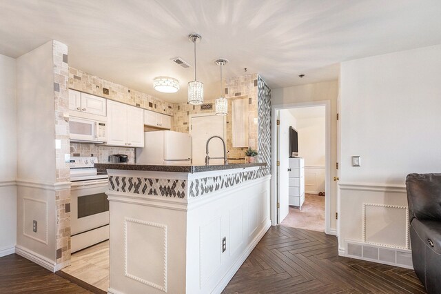 37510 Jefferson Ave Unit 203, Harrison Township, MI 48045 - kitchen featuring white appliances, dark countertops, a sink, a peninsula, and white cabinets