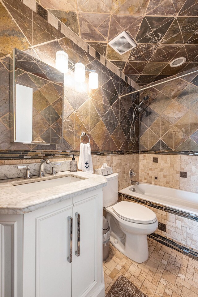 full bathroom with visible vents, vanity, toilet, tile walls, and tasteful backsplash