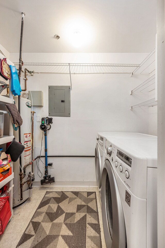 clothes washing area featuring gas water heater, electric panel, laundry area, and washer and clothes dryer