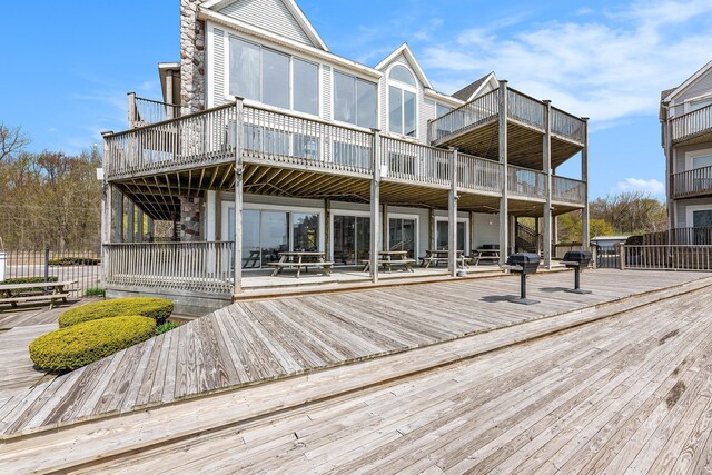rear view of property with stone siding and a deck
