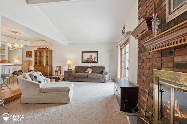 living room with carpet flooring, a notable chandelier, vaulted ceiling, and a fireplace