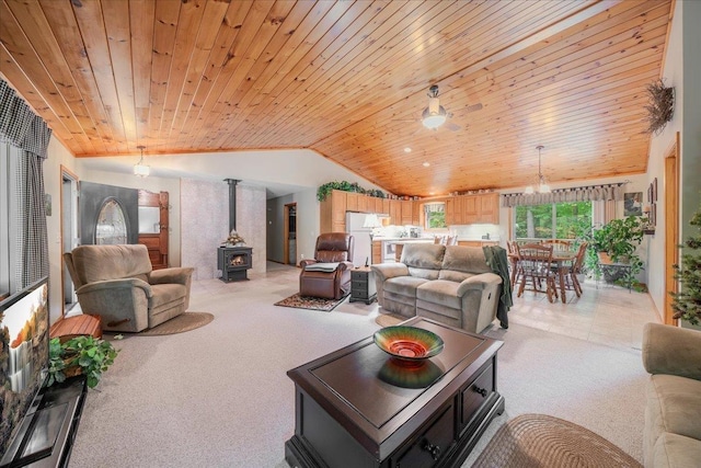 4335 Kings Corner Rd, Glennie, MI 48737 - living area with light colored carpet, a wood stove, wood ceiling, and vaulted ceiling