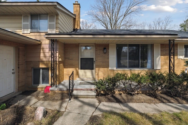 711 Sylvanwood Dr, Troy, MI 48085 - view of exterior entry with a chimney and brick siding