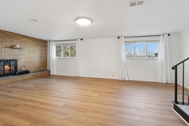 711 Sylvanwood Dr, Troy, MI 48085 - unfurnished living room with visible vents, baseboards, a fireplace, and light wood-type flooring