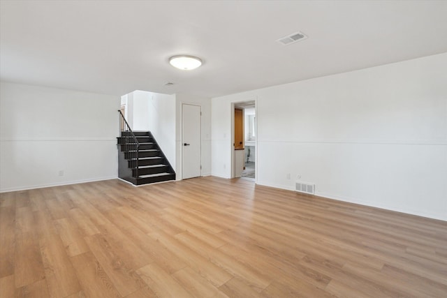 711 Sylvanwood Dr, Troy, MI 48085 - unfurnished living room featuring visible vents, stairs, and light wood-style floors