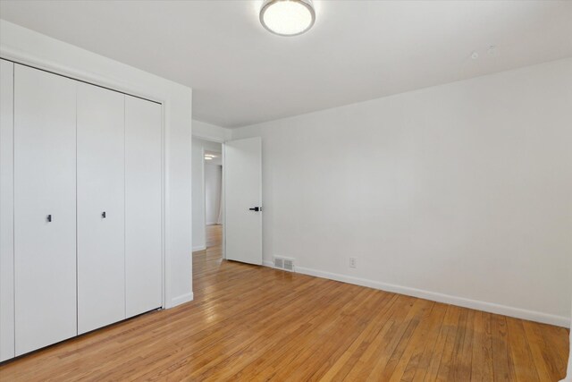 711 Sylvanwood Dr, Troy, MI 48085 - unfurnished bedroom with baseboards, visible vents, light wood finished floors, and a closet