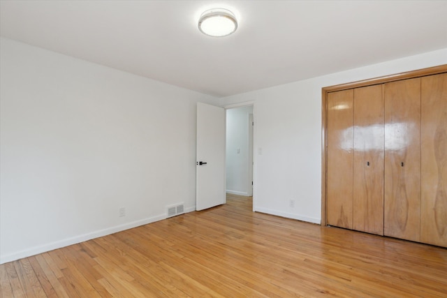 711 Sylvanwood Dr, Troy, MI 48085 - unfurnished bedroom featuring baseboards, visible vents, light wood finished floors, and a closet