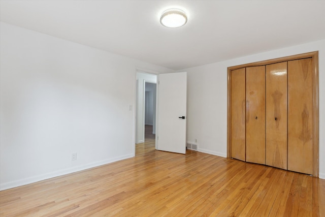 711 Sylvanwood Dr, Troy, MI 48085 - unfurnished bedroom featuring a closet, baseboards, visible vents, and light wood-type flooring