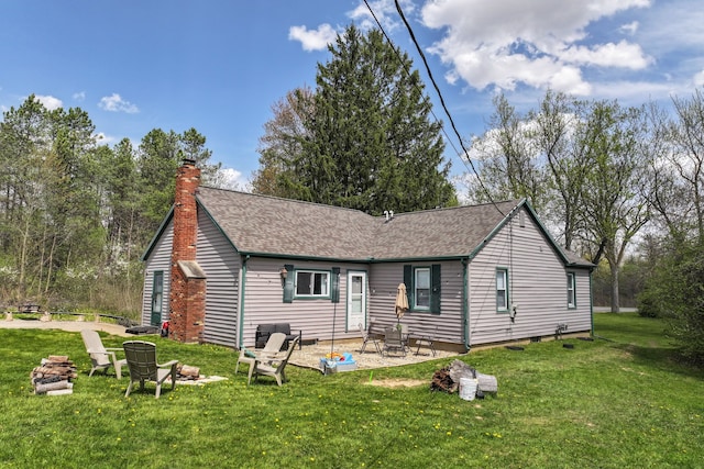 8119 N Dort Hwy, Mount Morris, MI 48458 - view of front facade with a shingled roof, an outdoor fire pit, a front lawn, a chimney, and a patio area