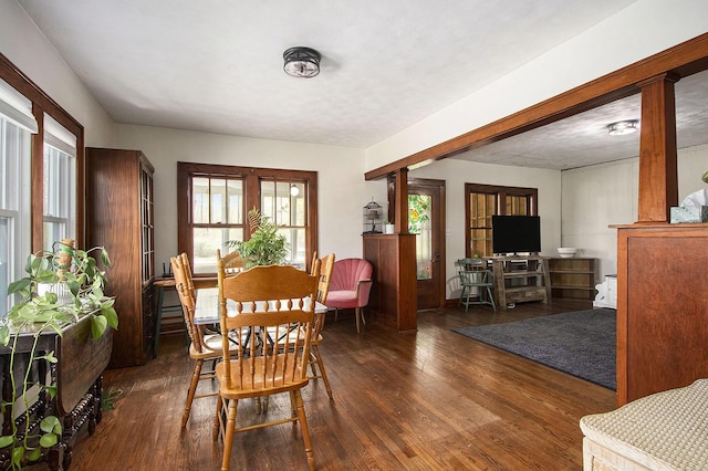 dining area with plenty of natural light, decorative columns, and wood finished floors