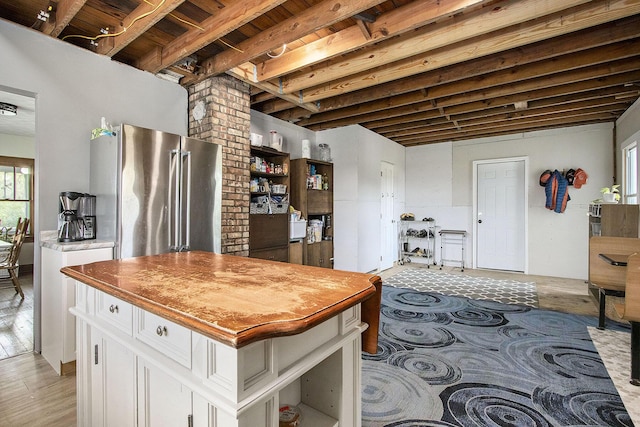 kitchen with white cabinets, freestanding refrigerator, light wood finished floors, and butcher block countertops