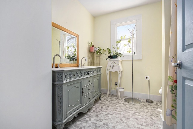 bathroom with vanity, baseboards, and tile patterned floors