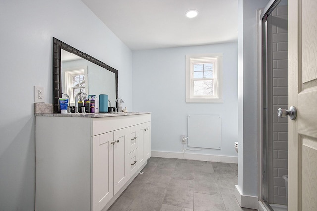 bathroom with vanity, baseboards, a shower stall, and toilet