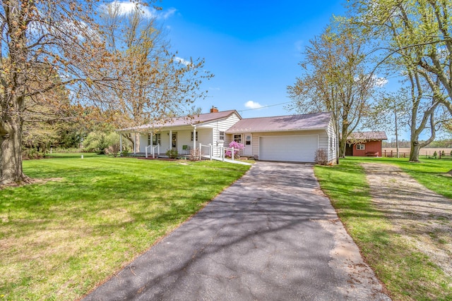 8531 S Waldron Rd, Pittsford, MI 49271 - single story home with a porch, a chimney, a garage, aphalt driveway, and a front lawn